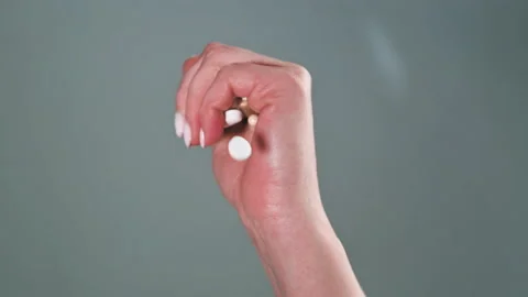 Hand in a pills they fall in slow motion. Theme of dependence on pharmaceutical Stock Footage 153020915