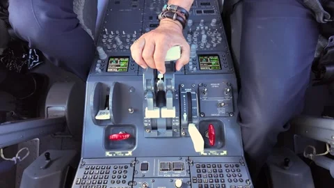 Hand of a Pilot Adjusting the Thrust Levers in a Modern Jet Airplane Cockpit in Stock Footage 338277015