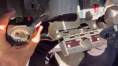 Hand of a Pilot on the Yoke of a Modern Jet Airplane, with the Cockpit Bathed Stock Footage 341344316