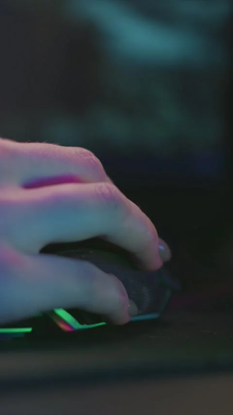 Hand with pink lighting operating glowing rgb computer mouse in close up Stock Footage 345976845