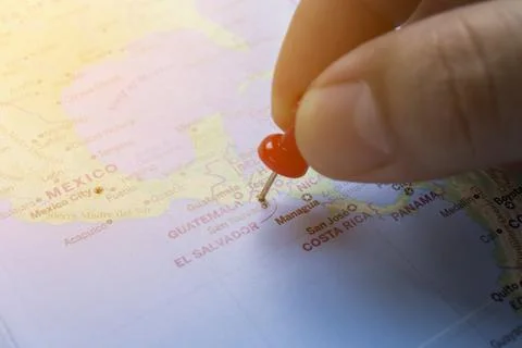 Hand pinned red on the world map of El Salvador. Stock Photos