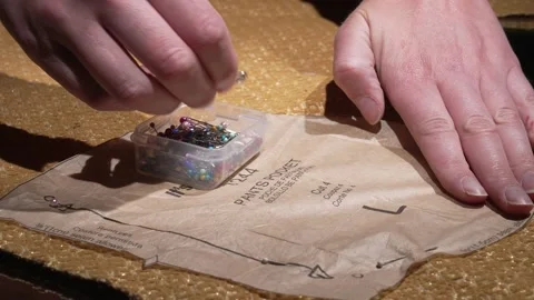 Hand pins pattern to fabric close up Stock Footage 152864476