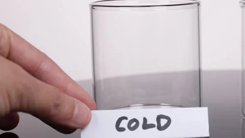 Hand Places 'Cold' Label on Empty Glass Beaker in Lab Stock Footage 319512725