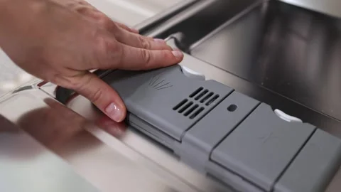 Hand places dishwasher detergent tablet into compartment, closes lid securely, Stock Footage 324301629