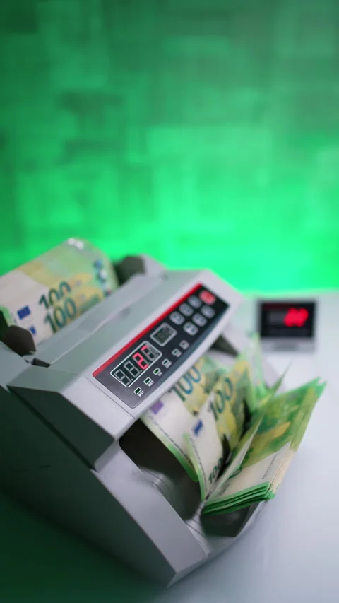 Hand places a large stack of one hundred euro bills to a money counting machine. Stock Footage 296004059