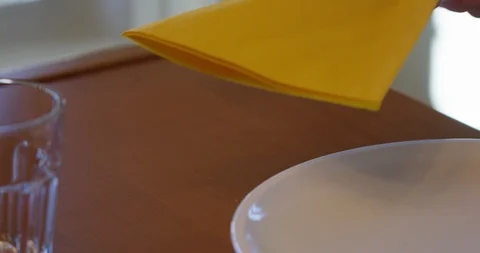 Hand places napkin down on dinner table - close up slow motion Stock Footage 88964571