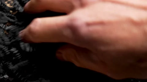 Hand places shredded black soft paper filling into cardboard gift box. Stock Footage 320543321