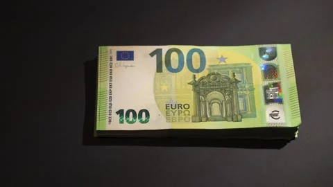 A hand places a stack of 100 Euro banknotes on a dark surface Stock-Footage 314382093