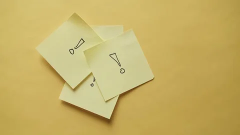 Hand places sticky note on yellow paper background Stock Footage 320222314