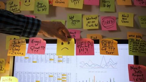 Hand places sticky notes on a computer monitor 스톡 사진