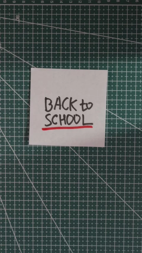 Hand placing Back to School paper note on green cutting mat Stock Footage 341246137