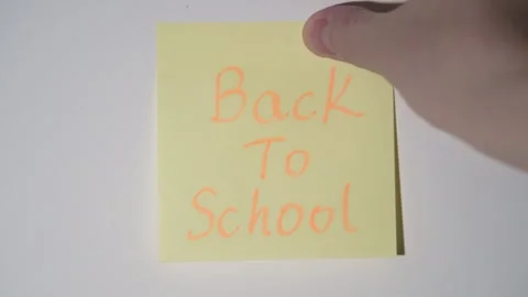 Hand Placing "Back To School" Sticky Note on Wall Stock Footage 344514316