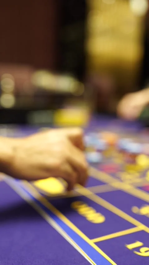 Hand Placing Bets with Chips on Purple Roulette Table Vertical Stock Footage 294804255