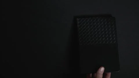 Hand placing black notebook on dark background Stock Footage 327288842