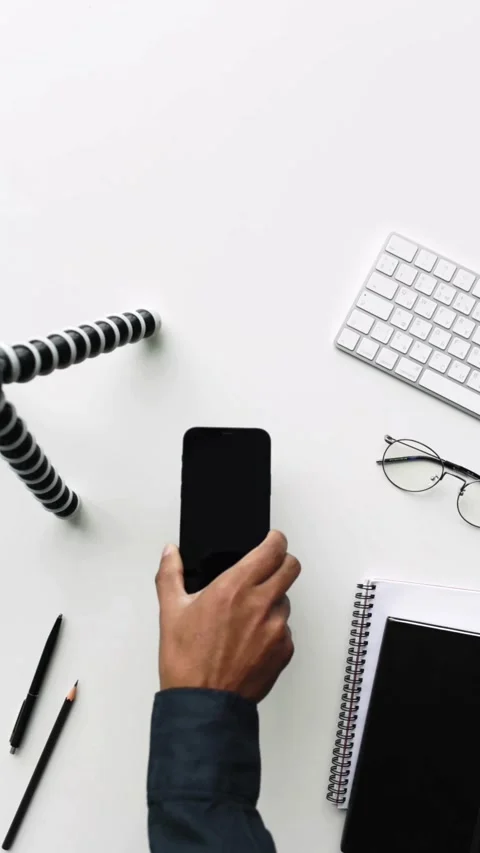 Hand placing black smartphone on white desk top view Video stock 331770099