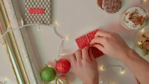 Hand placing bow on christmas present, christmas season 库存影片 220755784