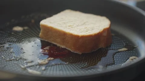 Hand placing bread slices on hot frying pan during breakfast cooking Stock Footage 340039993