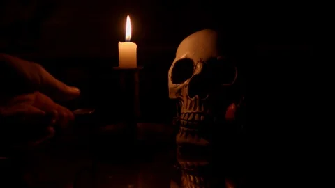 Hand placing candle next to skull with rose Stock Footage 114230565