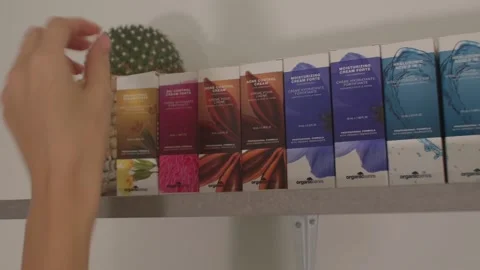 Hand placing cans paint. A row of multi-colored packages on the shelf. Vídeo Stock 163747794