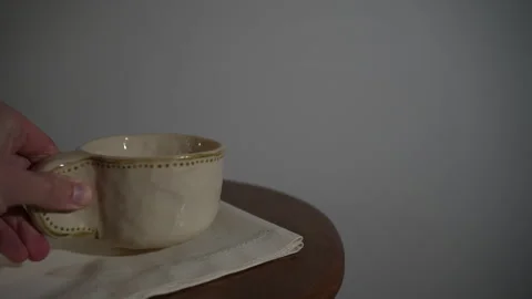 Hand placing coffee cup back on table Video stock 327350107
