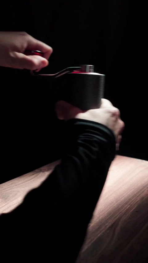 Hand Placing Coffee Grinder on Table Dark 4K Stock Footage 325392964