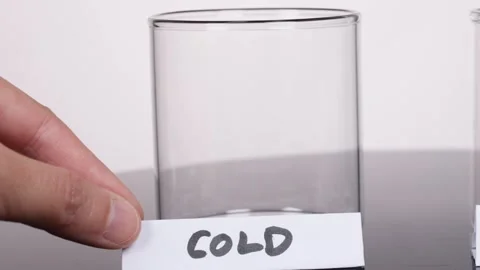 Hand Placing Cold Label on Empty Glass in Laboratory Setting Stock Footage 318703015