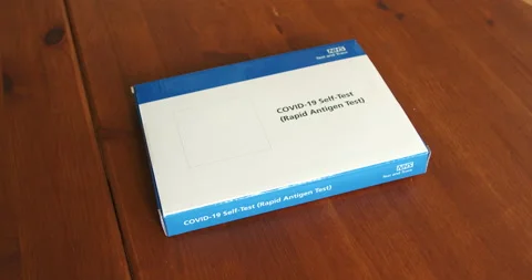 A hand placing the Covid-19 Self-Test (Rapid Antigen Test) pack Stock Footage 158396005