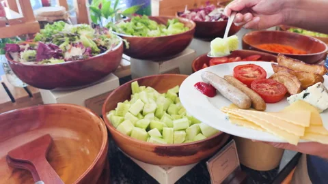 A hand placing cucumbers on a breakfast plate. Stock Footage 318474242
