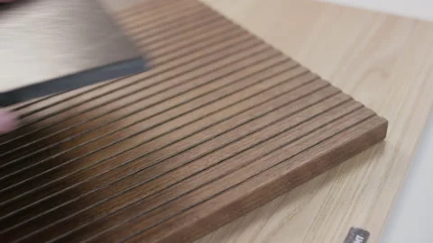 Hand placing dark marble stone tile sample on wooden slats for interior design Stockbeeldmateriaal 155205576