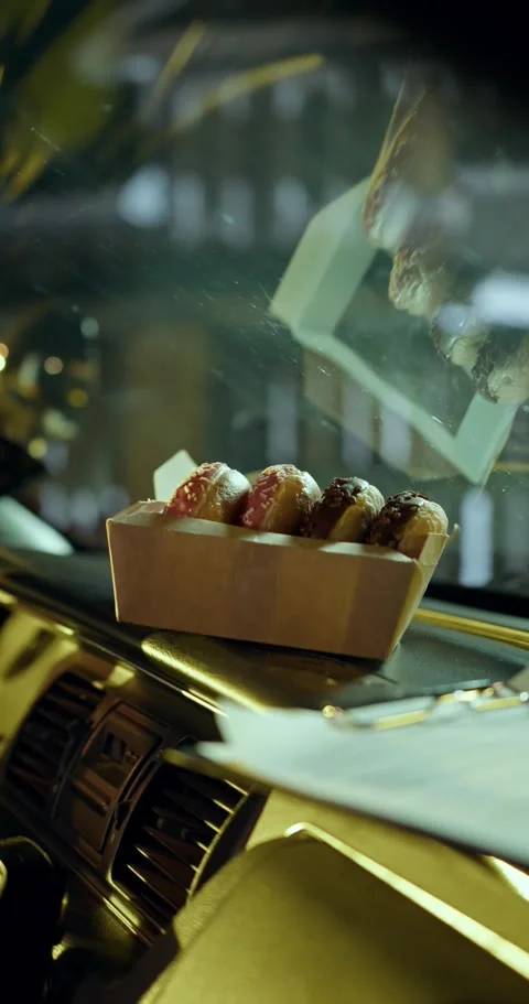 Hand Placing Donut Box on Car Dashboard at Night Video stock 326723138