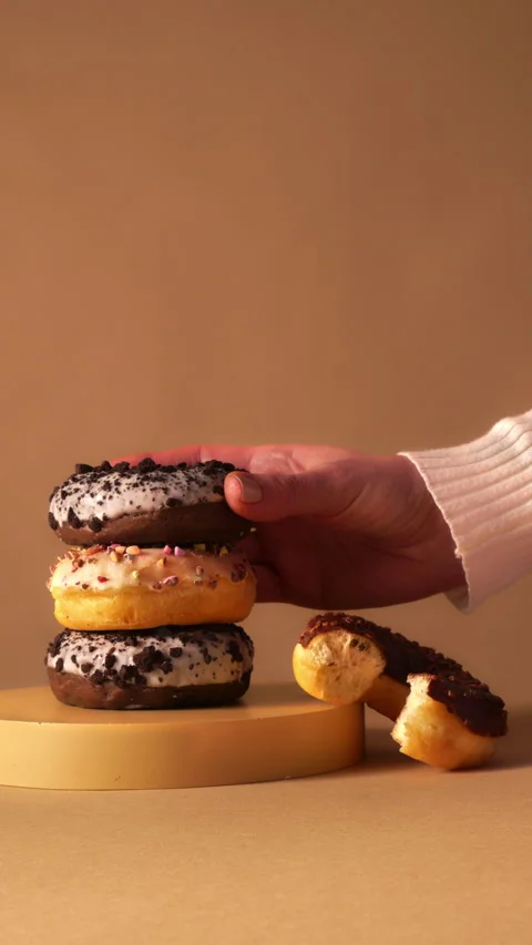Hand Placing Donut on Stack with Bite Detail on Minimal Podium 動画素材 331232335