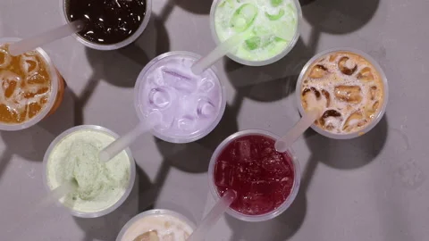 Hand placing down delicious milk tea drink with crushed ice. Stock Footage 156197467