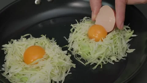 Hand Placing Egg on Cabbage in Skillet Cooking Stock-Footage 341423357