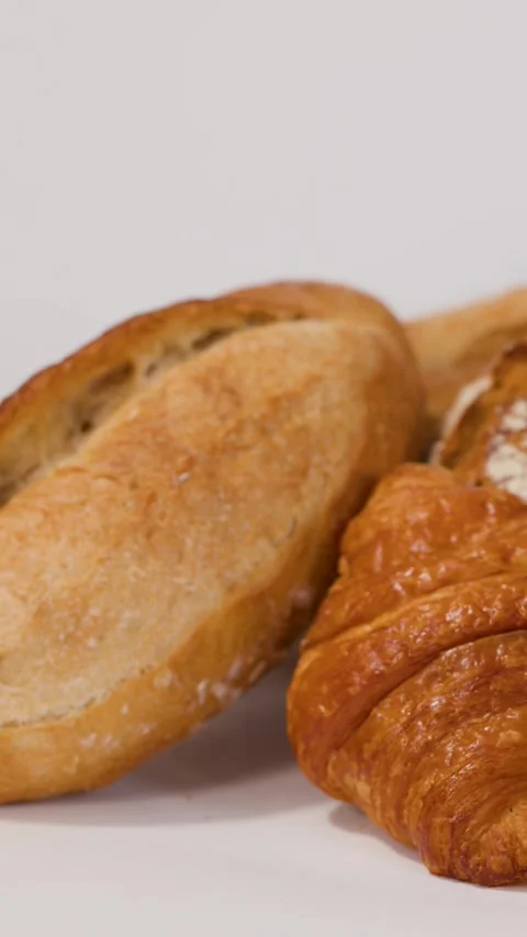 Hand Placing Fresh Crusty Bread Loaf Next to Croissant Stock Footage 337224932