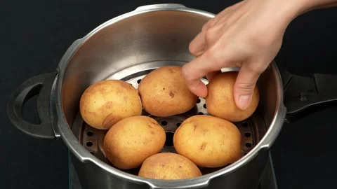 Hand Placing Fresh Raw Potatoes into Steamer Pot Stock Footage 343934354