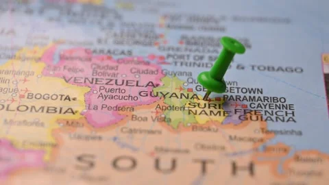 Hand Placing Green Pin on Guyana Location in World Map Stock Footage 333568103