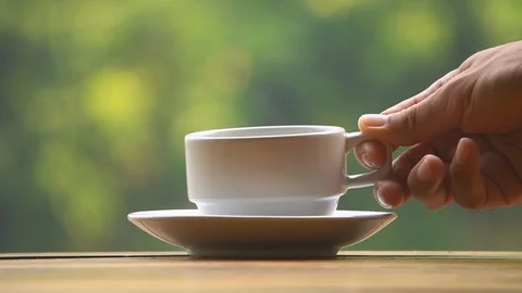 Hand placing hot coffee cup with smoke on saucer Stock Footage 113908014