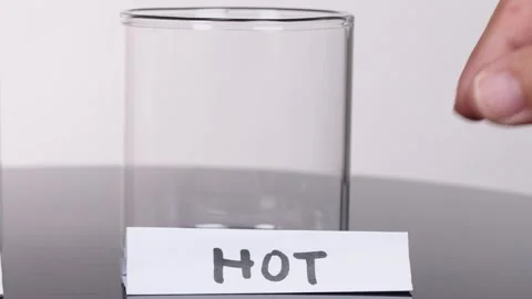 Hand Placing 'Hot' Label on Empty Glass Beaker Stock Footage 318943009