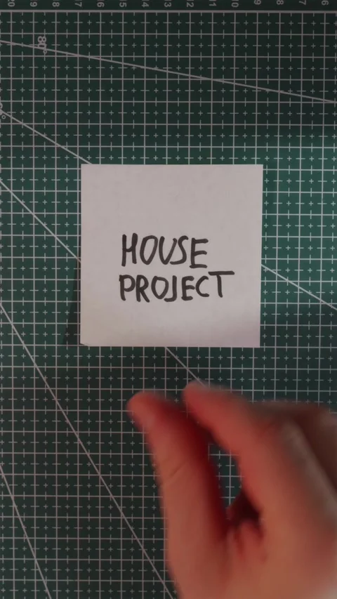 Hand placing House Project handwritten note on grid mat Stock Footage 341245987
