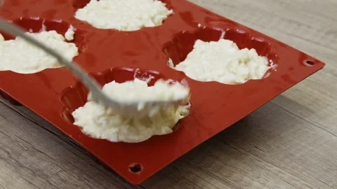 A hand placing ingredients into a muffin pan. Stock Footage 266425587