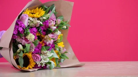 Hand placing a love note by a well arranged floral composition Stock-Footage 124664090