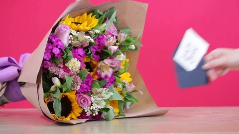 Hand placing a love note by a well arranged floral composition Video stock 124664129