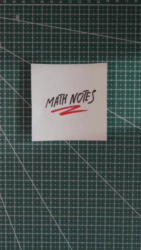 Hand placing Math Notes paper slip on green cutting mat Stock Footage 341246122