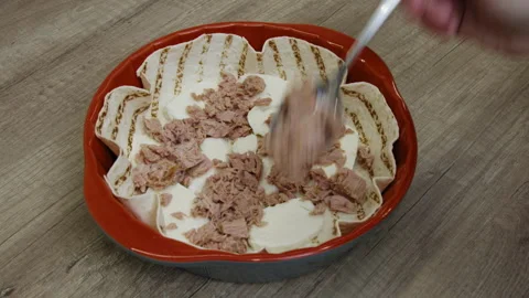 Hand placing meat on mozzarella slices over tortilla in a baking dish. Stock Footage 266421118