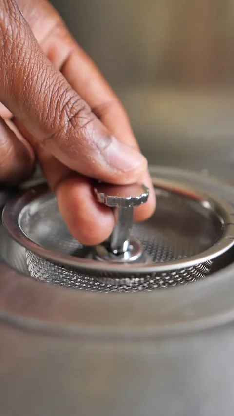 Hand Placing Metal Sink Strainer into Drain Stock Footage 346873320