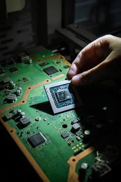 Hand placing microprocessor on board. 스톡 사진