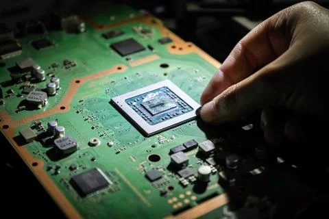 Hand placing microprocessor on board. Stock Photos