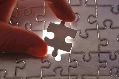 Hand placing missing puzzle piece Stock Photos