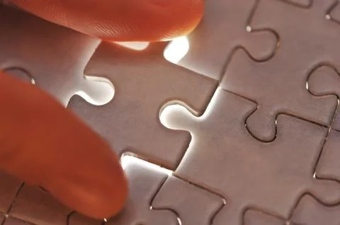 Hand placing missing puzzle piece Stock Photos