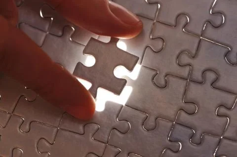 Hand placing missing puzzle piece Stock Photos